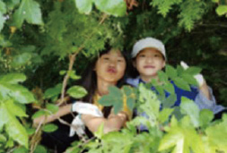 풀숲에서 사진을 찍고있는 여자 아이들